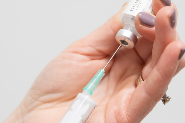 hand met spuit en ampul